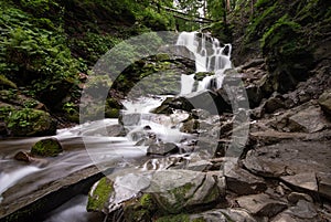 Beautiful mountain rainforest waterfall with fast flowing water and rocks, long exposure.