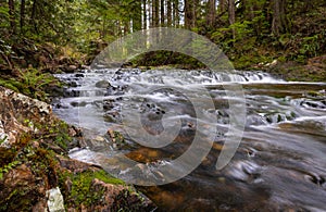 Beautiful mountain rainforest waterfall with fast flowing water and rocks, long exposure