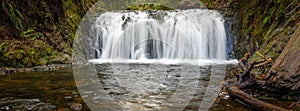 Beautiful mountain rainforest waterfall with fast flowing water and rocks, long exposure