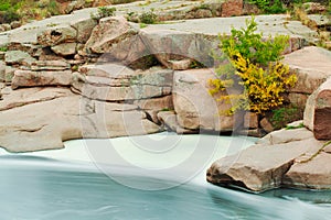 Beautiful mountain river flowing over rocks. Flow of water in mountain river close up