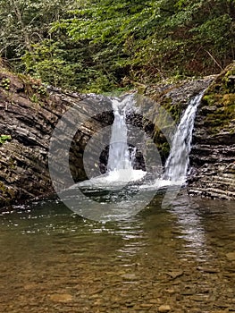 Beautiful mountain waterfall, double waterfall, mountain river. Mountain river in the forest