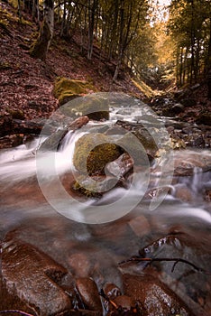 Beautiful mountain waterfall with fast flowing water and rocks, long exposure.