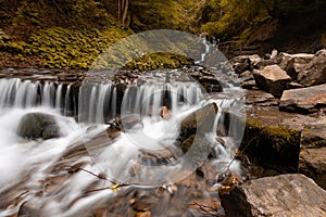 Beautiful mountain waterfall with fast flowing water and rocks, long exposure.