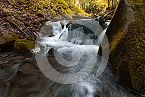 Beautiful mountain waterfall with fast flowing water and rocks, long exposure.