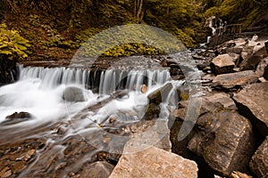 Beautiful mountain waterfall with fast flowing water and rocks, long exposure.