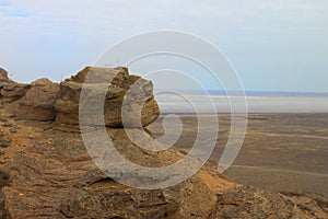 Beautiful mountainous terrain. Steppe panoramic landscape with rocky mountain, dry grass, and blue sky and lake. View from a