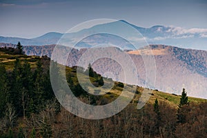 Beautiful mountains landscape in spring. Springtime in mountains.  View of forested hills and grassy slopes illuminated with sunsh