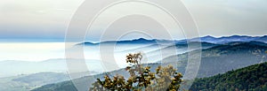 Beautiful mountains landscape from the top of the hill with fog