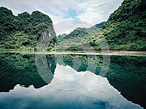 Beautiful mountains reflection on water lake of Tam Coc, Vietnam