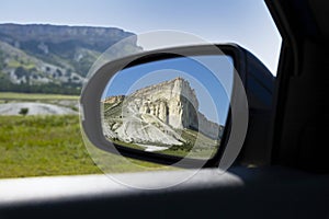 Beautiful mountains, White Rock, wildlife in the rearview mirror of the car. Car travel concept