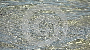 Beautiful moving water surface at a baltic sea beach with sunlight caustics