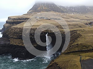 Beautiful Mulafossur waterfall in the Faroe Islands on a gloomy day