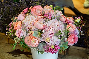 Beautiful multi-colored bouquet of mixed roses and other flowers in a shop. Fresh cut flowers placed in white flower pot