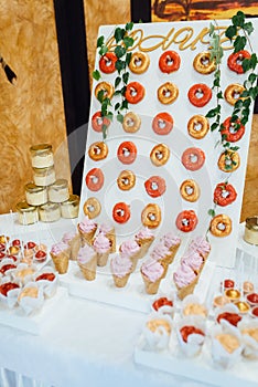 Beautiful multicolored decorated candy table baked sweet tasty cupcake cupcakes on a party.