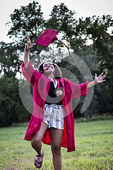 Beautiful multiethnic woman celebrating in her graduation cap and gown