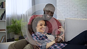 Beautiful multiracial couple having pleasant pastime together at home, marriage
