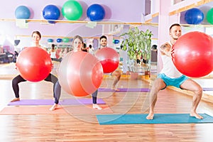 Beautiful multiracial women and man doing exercise with gimnastic ball.