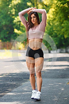 Beautiful muscular girl posing outdoor. athletic woman with big quads photo