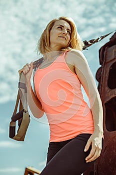 Beautiful muscular woman with trx system outdoor city urban.