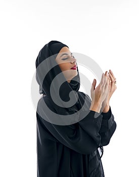 Beautiful muslim arabic woman praying on grey