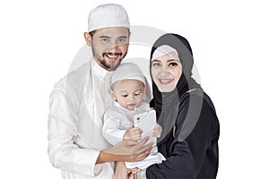 Beautiful muslim family and son smiling in studio