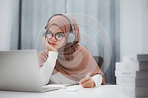 Beautiful muslim student girl using a laptop computer learning online at home. Distance learning online education