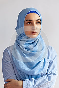 Beautiful Muslim woman in hijab against white background. Portrait of pretty middle-eastern female wearing traditional Islamic