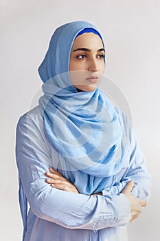 Beautiful Muslim woman in hijab against white background. Portrait of pretty middle-eastern female wearing traditional Islamic