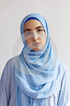 Beautiful Muslim woman in hijab against white background. Portrait of pretty middle-eastern female wearing traditional Islamic