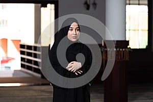 Beautiful Muslim woman in Hijab Dress praying in Mosque.