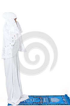 Beautiful muslim woman praying on carpet - isolated