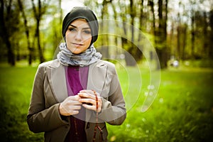 Beautiful muslim woman wearing hijab praying on rosary / tespih