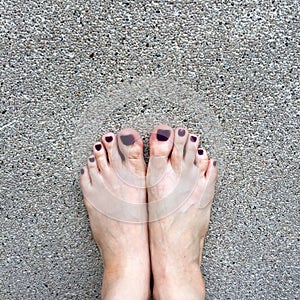 Beautiful Nail, Close Up Woman`s Bare Feet and Red Nail Polish on Cement Floor Background