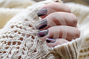 Beautiful nail polish in hand, purple nail art manicure, white background
