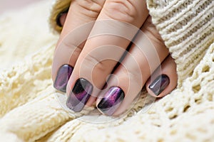 Beautiful nail polish in hand, purple nail art manicure, white background