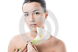 beautiful naked girl holding white calla flower and looking at camera