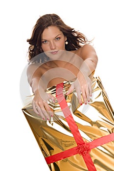 Beautiful naked woman behind a big Christmas gift