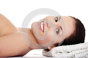 Beautiful naked woman is lying and smiling.