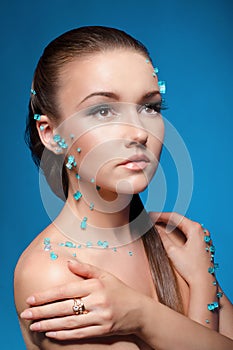 Beautiful naked young woman covered with blue crystals