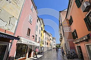 Beautiful narrow street with ancient building facades and paving stones in the coastal town of Rovinj, Croatia