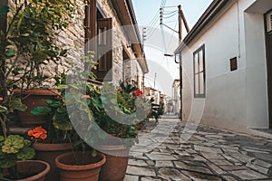 Beautiful narrow street of Pano Lefkara village, Cyprus with flower pots and masonry
