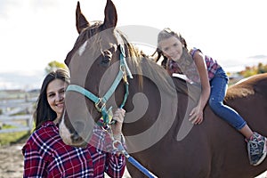 Beautiful and natural adult woman outdoors with horse child