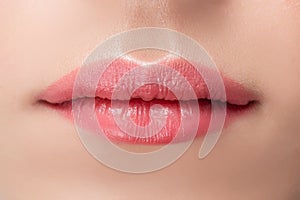 Beautiful natural female lips close-up with pink permanent makeup stick