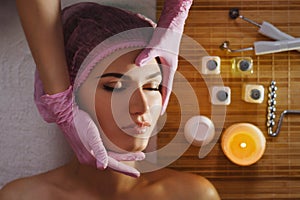 Beautiful natural girl woman in the spa salon, It makes a face mask