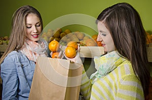 Beautiful natural girls buying oranges