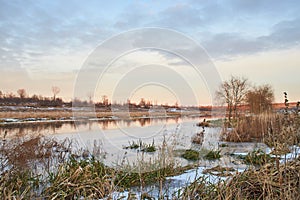 Beautiful natural landscape with birch and frozen river in winter.