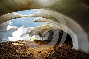 Beautiful natural phenomenon in Landmannalaugar, Iceland. Melting snow over the flowing river. Snow tunnel.