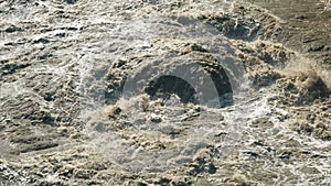 Beautiful natural phenomenon slow motion torrent of a stormy mountain river. Flash flood muddy river. Rushes river