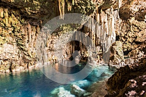 Beautiful natural pool of crystal clear water formed in a rocky cave with stalagmites and stalagmites