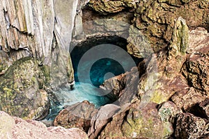 Beautiful natural pool of crystal clear water formed in a rocky cave with stalagmites and stalagmites